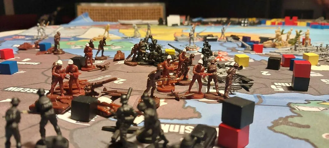 Close-up of the board: plastic soldiers, tanks and coloured blocks on the map